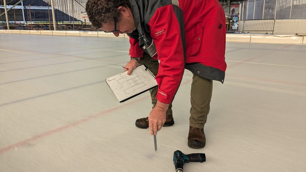 Tonny meet de dikte van het ijs.