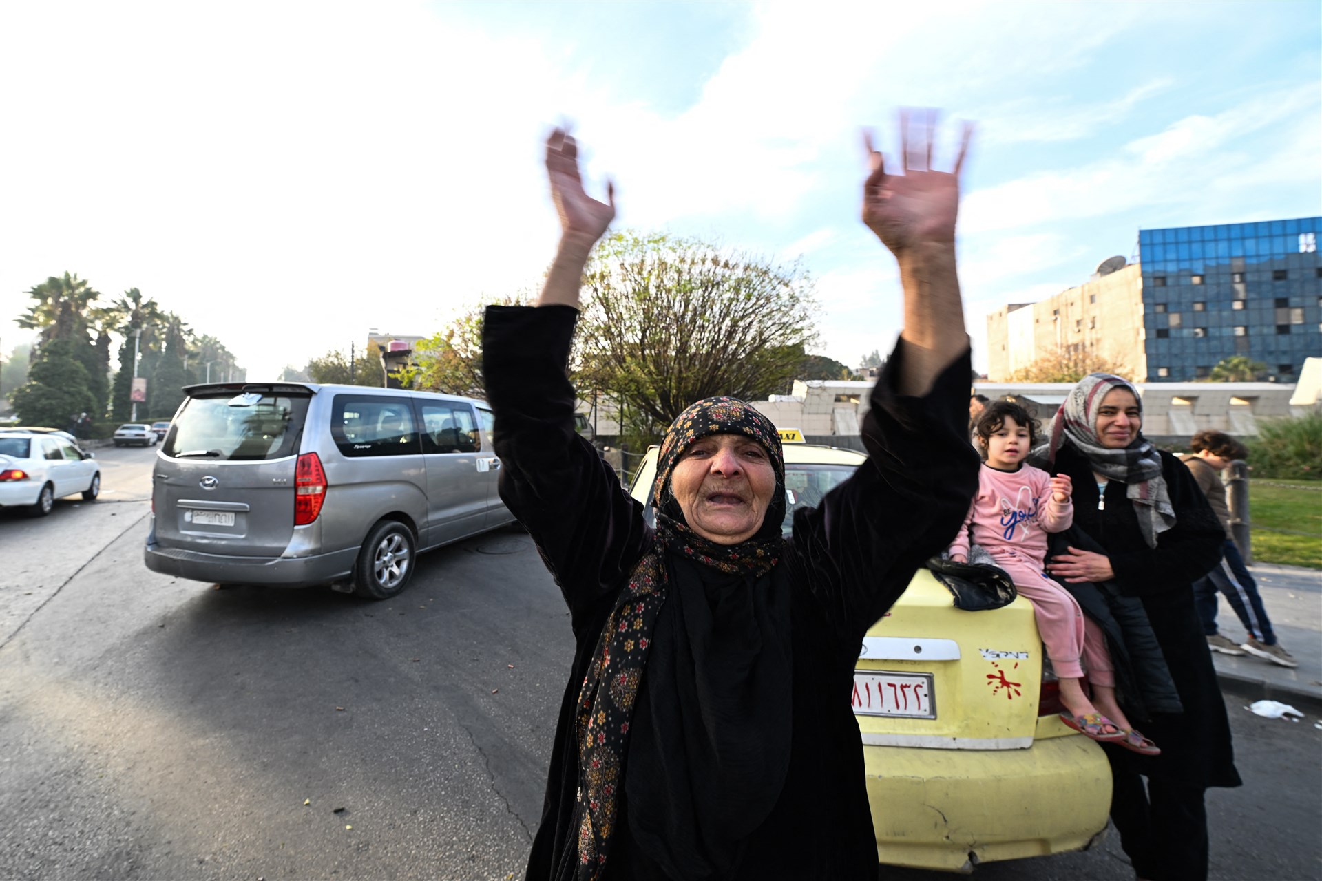 Een oudere vrouw viert feest op het Umayyadplein in Damascus.