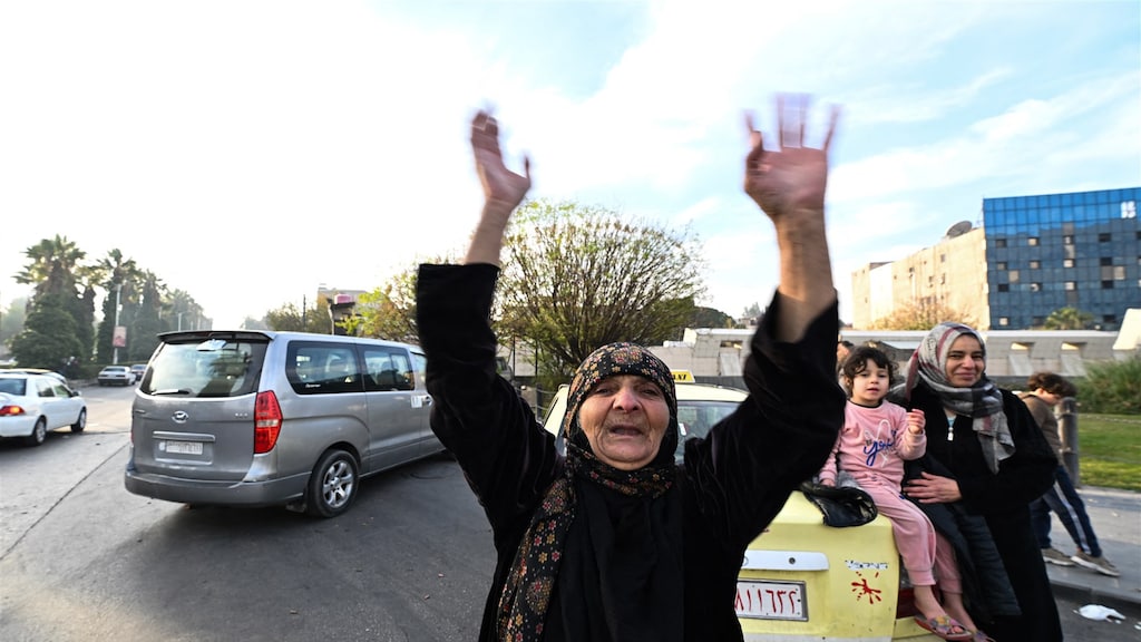 Een oudere vrouw viert feest op het Umayyadplein in Damascus.