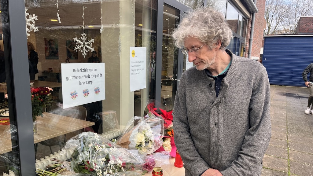 Ingo Wewer kijkt naar de bloemen op een gedenkplek in zijn wijk.