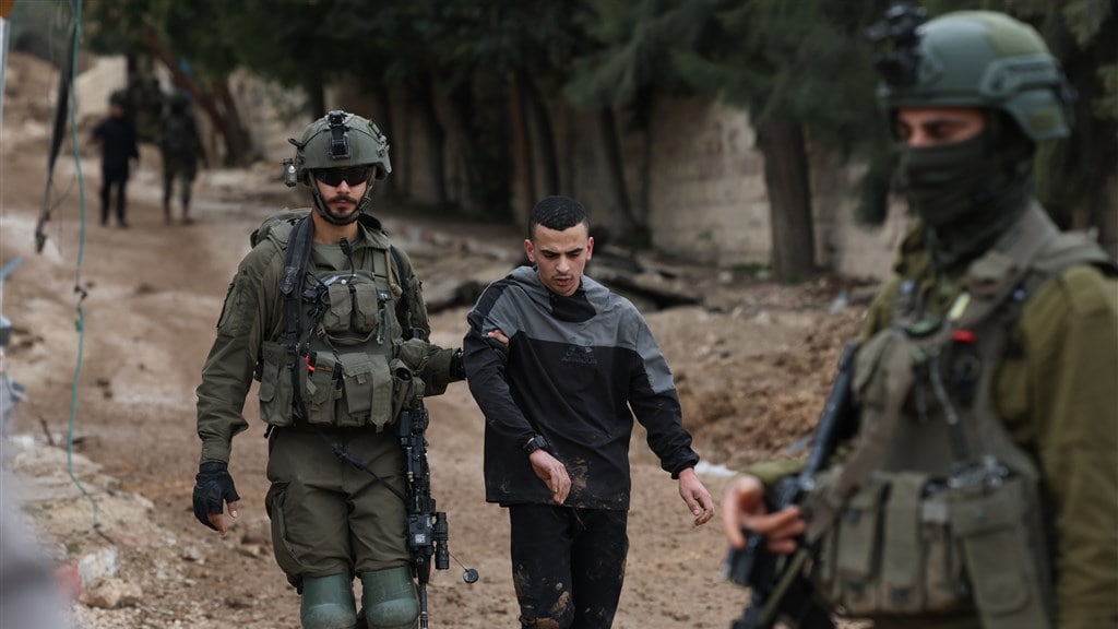 Een jonge Palestijnse man op de Westelijke Jordaanoever wordt door Israelische militairen gearresteerd.
