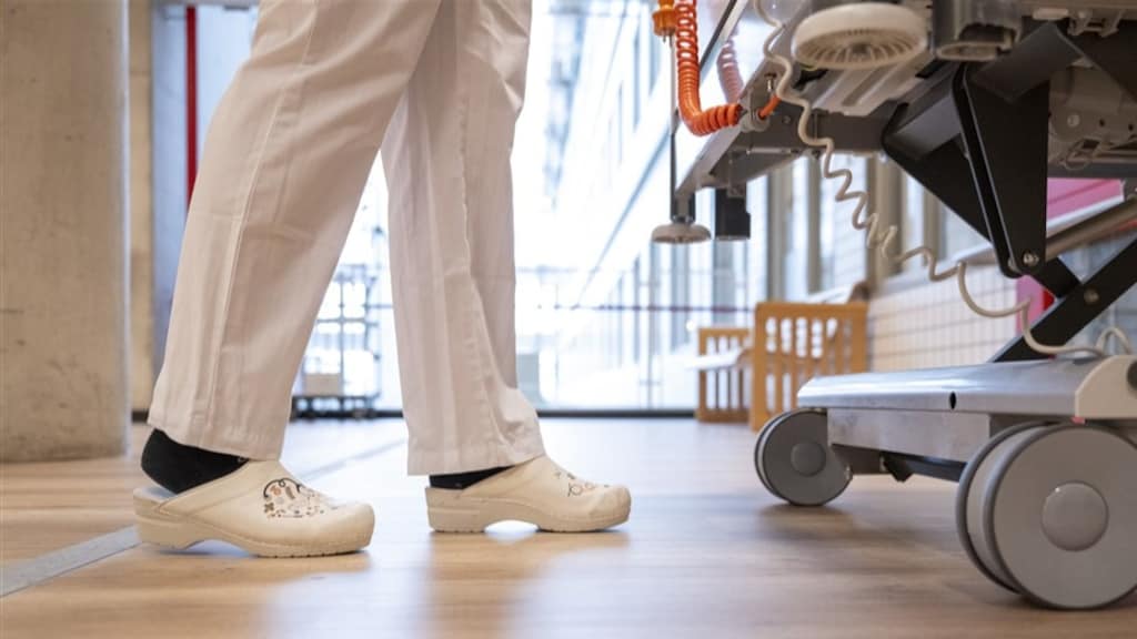Verpleegkundigen dragen vaak een witte broek, wit overhemd en klompen.