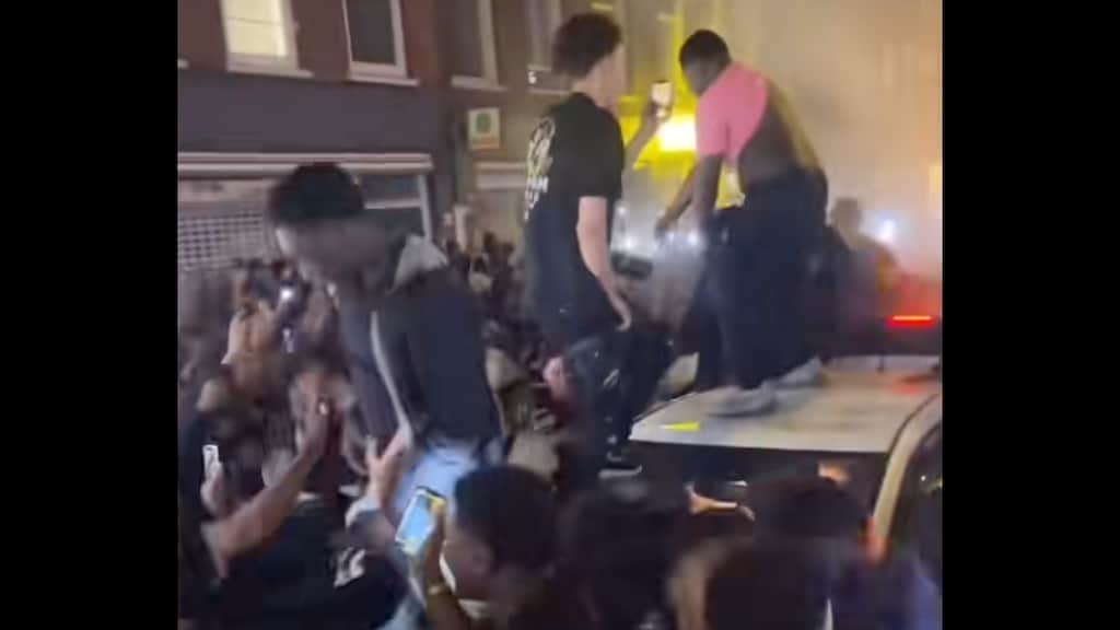 Menigte omsingelt auto gemeente Amsterdam, politie grijpt in 'tegen geluidsoverlast'