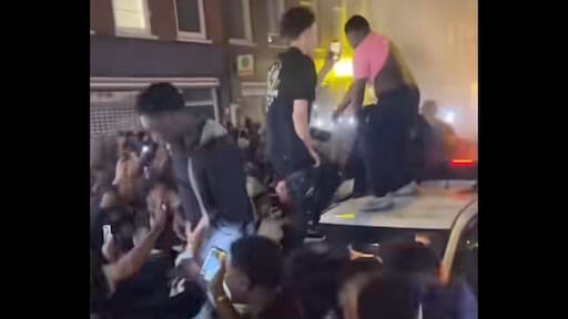 Menigte omsingelt auto gemeente Amsterdam, politie grijpt in 'tegen geluidsoverlast'