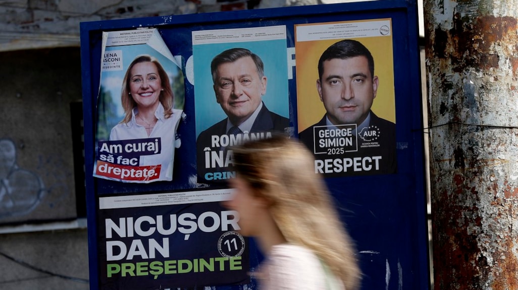 Een poster in Boekarest waarop kandidaten Lasconi, Antonescu en Simion te zien zijn.