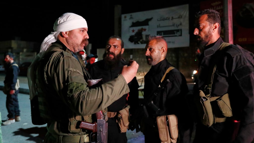 Een druzen-schutter (links) spreekt met Syrische veiligheidstroepen die een akkoord hebben bereikt.