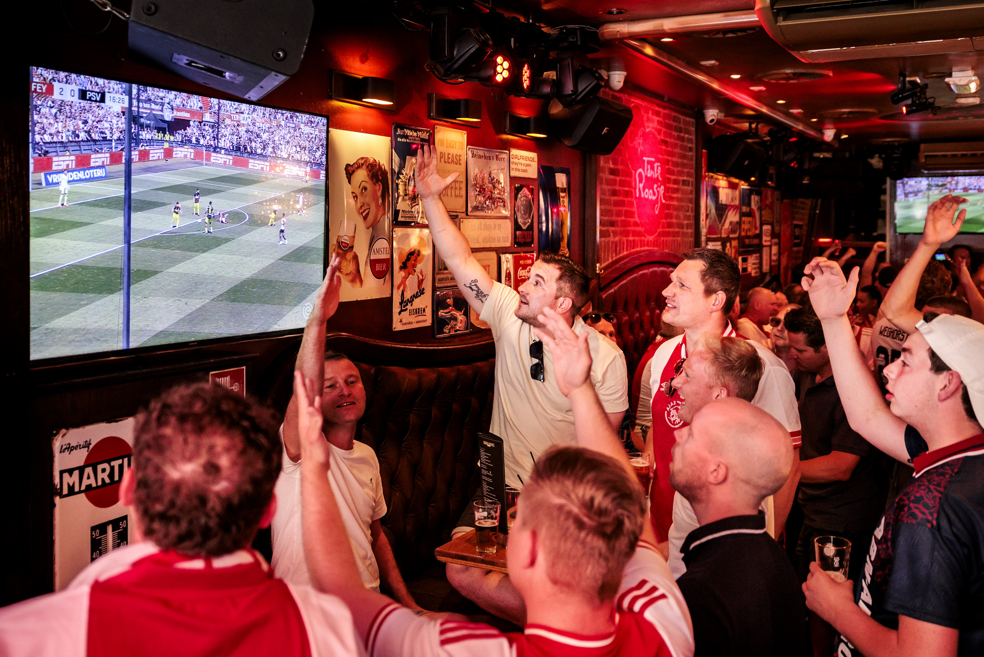 Ajax-fans juichen voor Feyenoord in een Amsterdamse kroeg