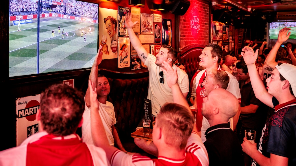 Ajax-fans juichen voor Feyenoord in een Amsterdamse kroeg
