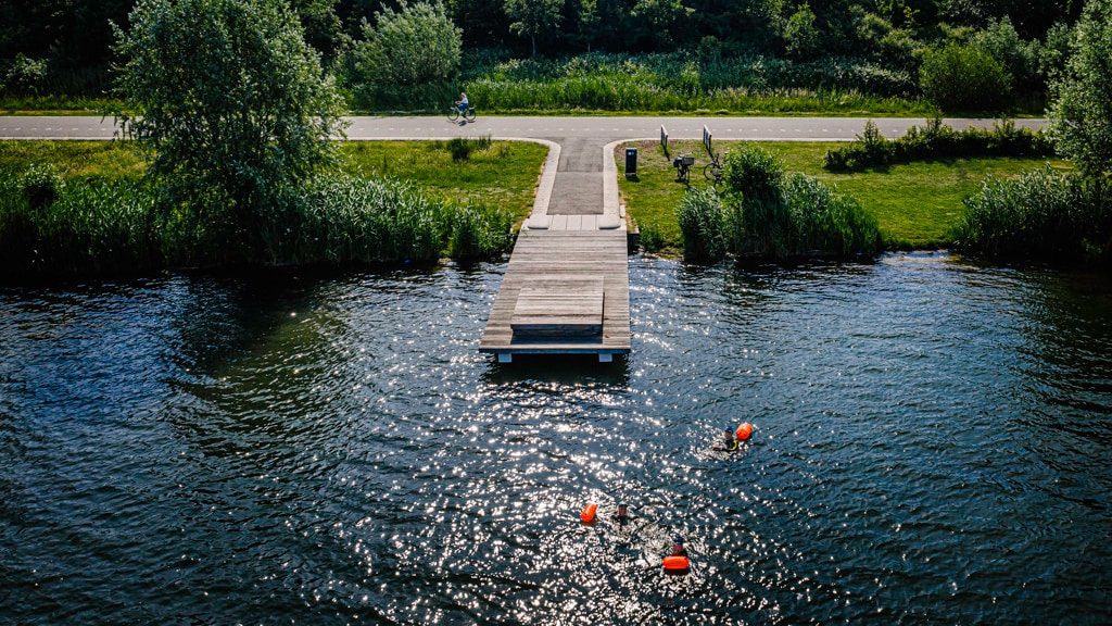 Zwemmers met een zwemboei in natuurwater.