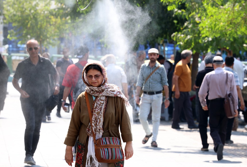 Tijdens de huidige hittegolf is er op straat in Teheran ook een waterverstuiver voor wat verkoeling.