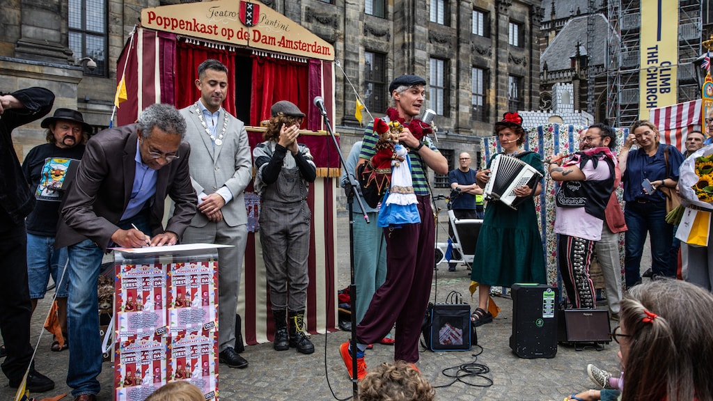 Poppenkastspeler Egon (midden) bij de ceremonie in Amsterdam.