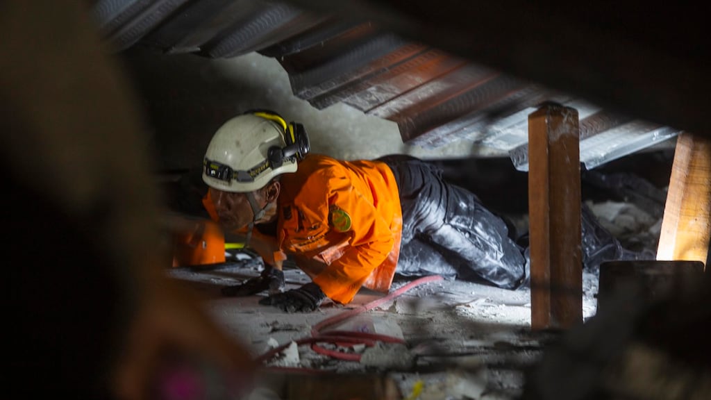 Een reddingswerker zoekt naar overlevenden.
