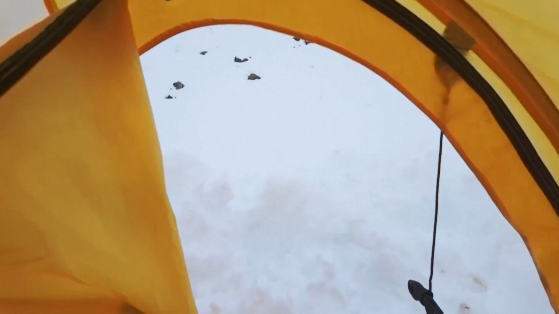 Buiten de tent is een grote hoeveelheid sneeuw te zien.