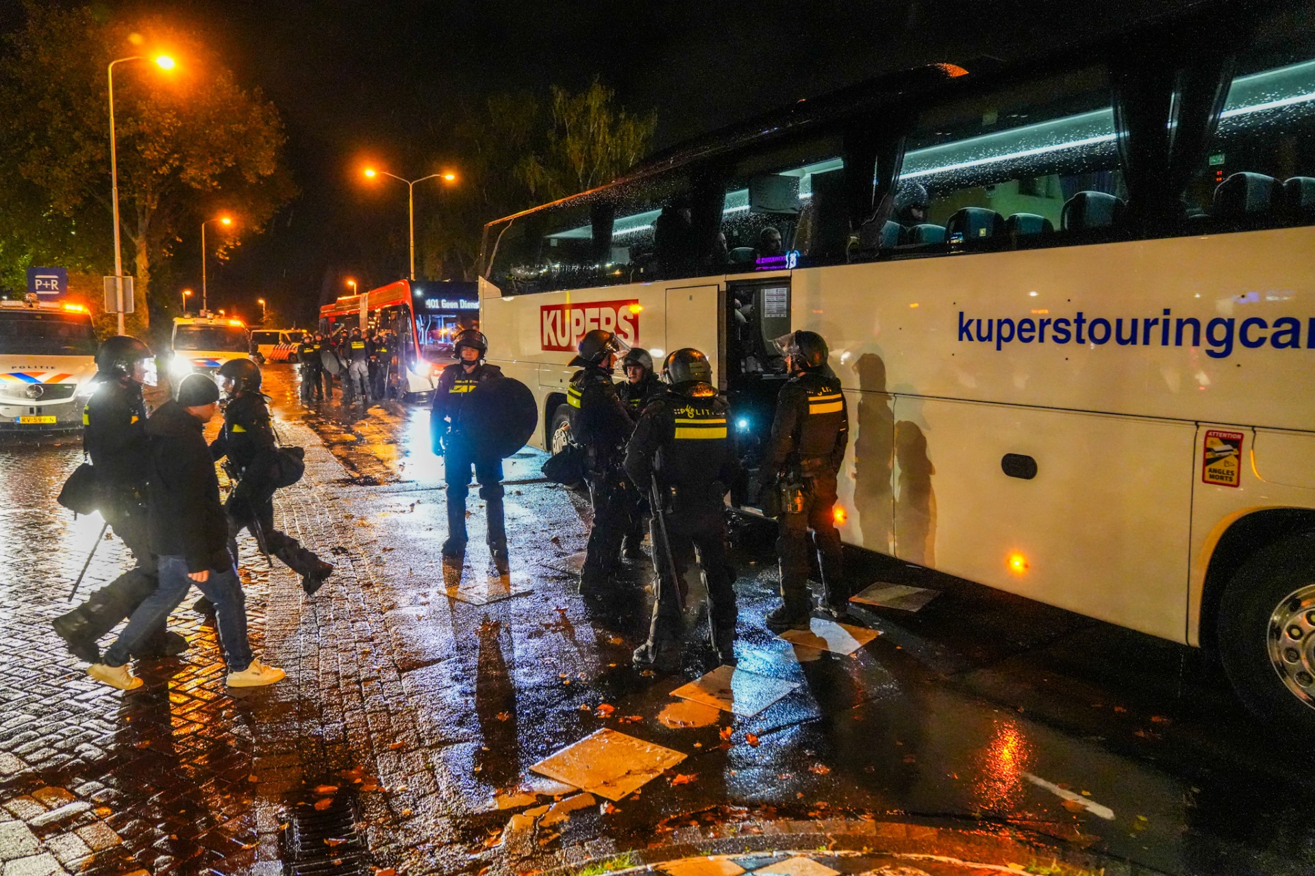 De Napoli-supporters worden door de politie naar bussen begeleid.