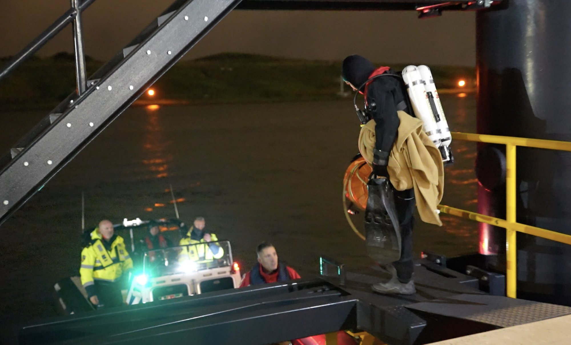 Duikers stappen aan boord van een reddingsboot.