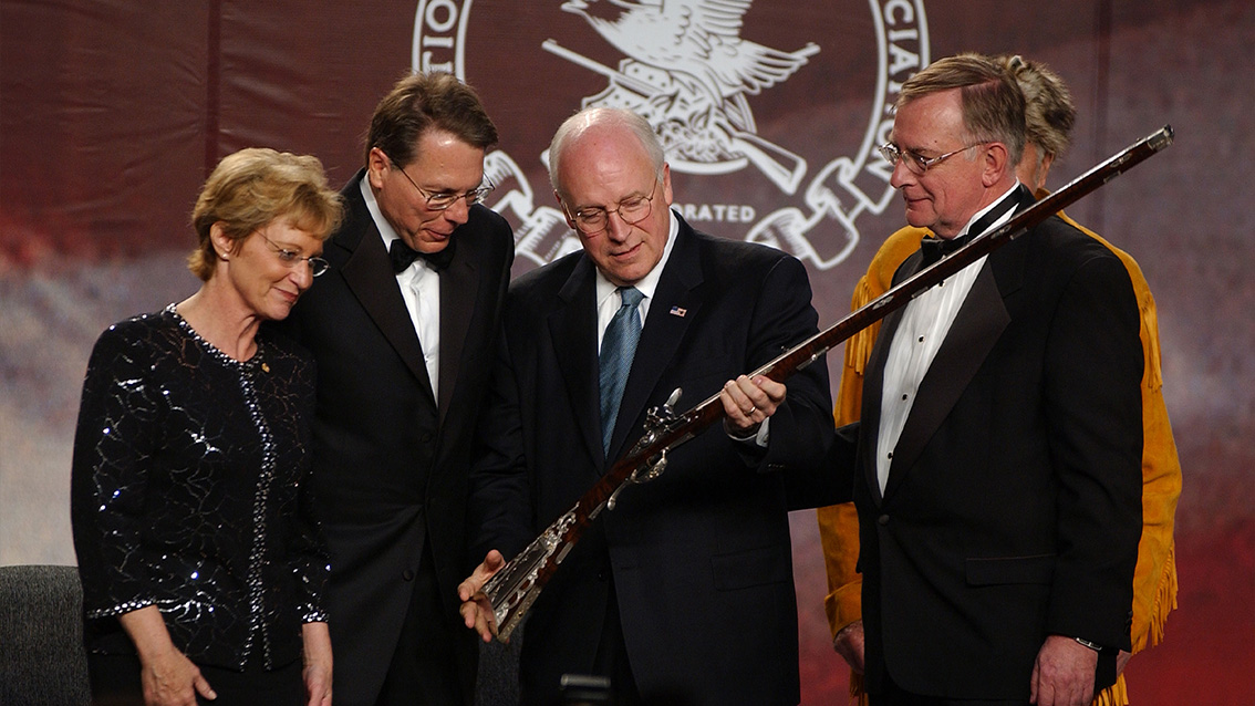 Dick Cheney inspecteert een oud geweer.