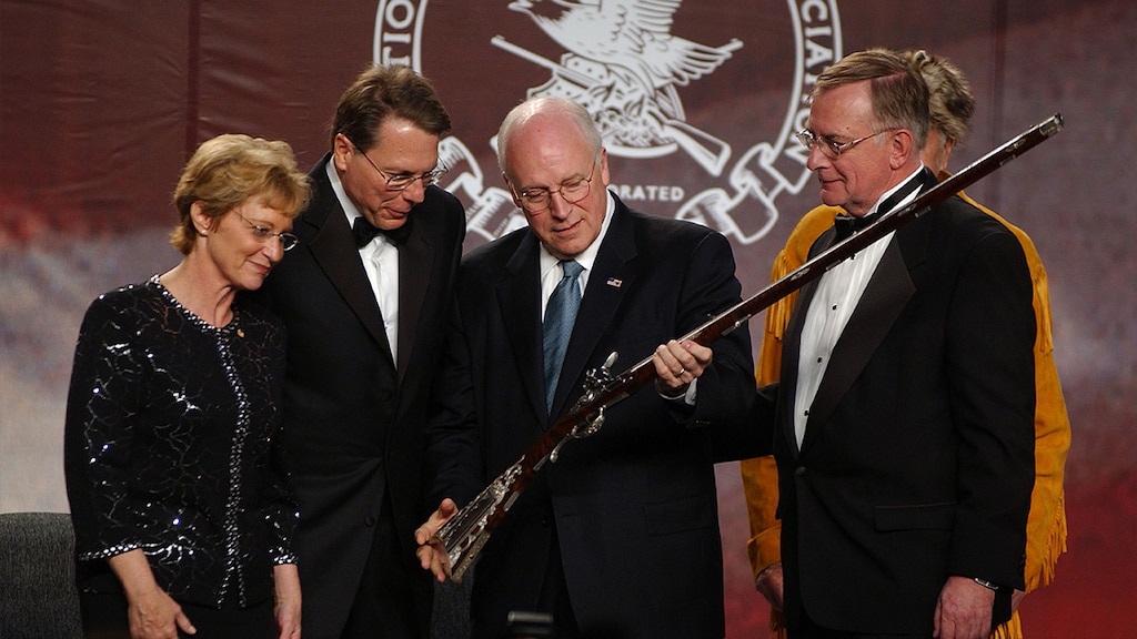 Dick Cheney inspecteert een oud geweer.