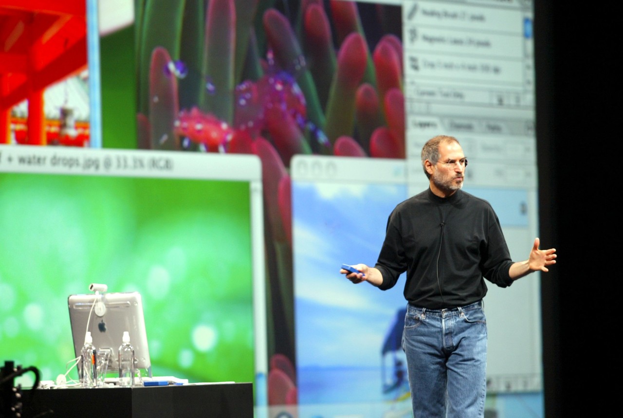 Steve Jobs in zijn bekende zwarte coltrui ontworpen door Issey Miyake.