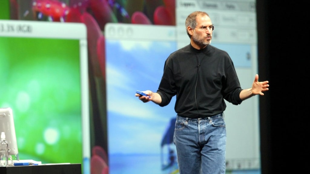 Steve Jobs in zijn bekende zwarte coltrui ontworpen door Issey Miyake.