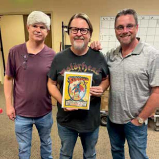 Medewerkers van het veilinghuis met het stripboek.