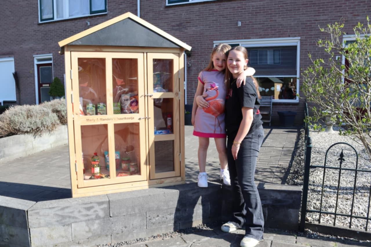 Mandely (links) en Marly (rechts) bij hun buurtkastje.