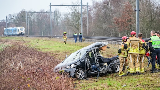 Auto belandt onder trein bij spoorwegovergang Loozen, bestuurder naar ziekenhuis