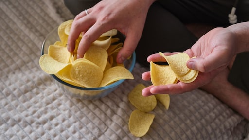 Avondje chips op de bank? Waarom het zelden bij één handje blijft