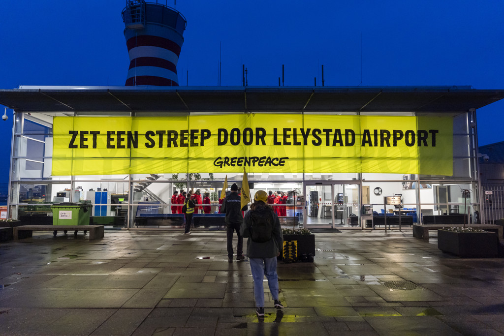 Slaapzakken en kratten proviand: Greenpeace bezet vliegveld Lelystad