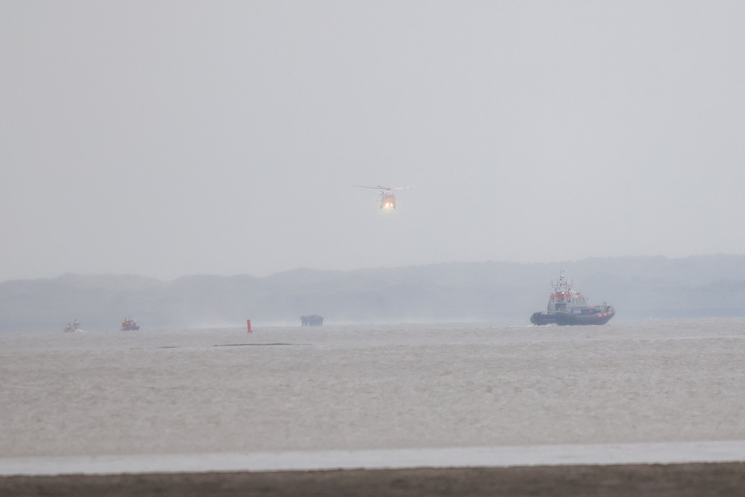 Gestrande wadlopers met reddingsboten en heli van wad gehaald