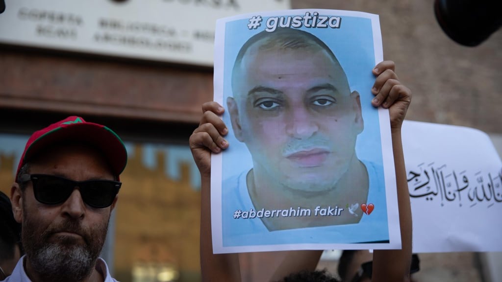 Een demonstrant houdt in de straten van Bologna een portret van Fakir omhoog.