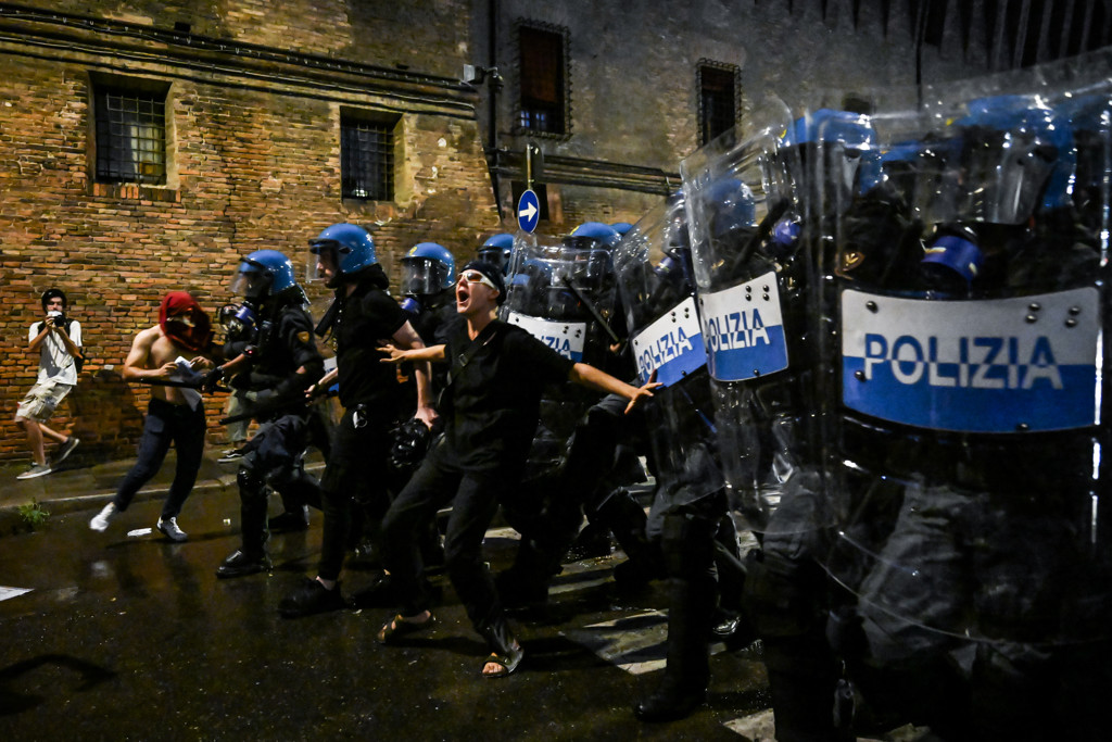 Een demonstrant in Bologna probeert de politie tegen te houden