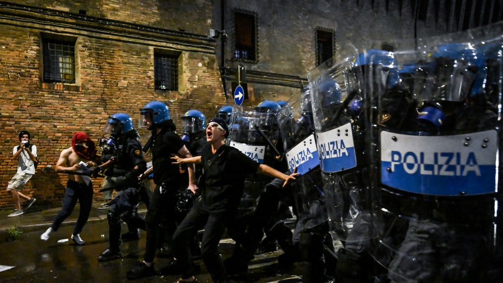 Een demonstrant in Bologna probeert de politie tegen te houden